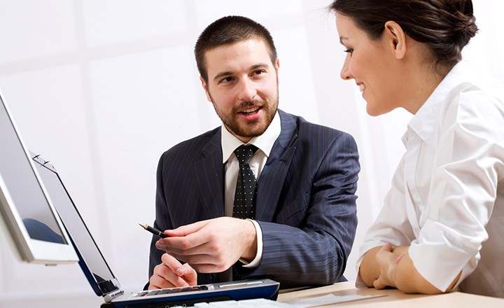 Man and Woman Talking at a Computer