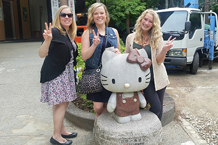 Students pose next to Hello Kitty statue