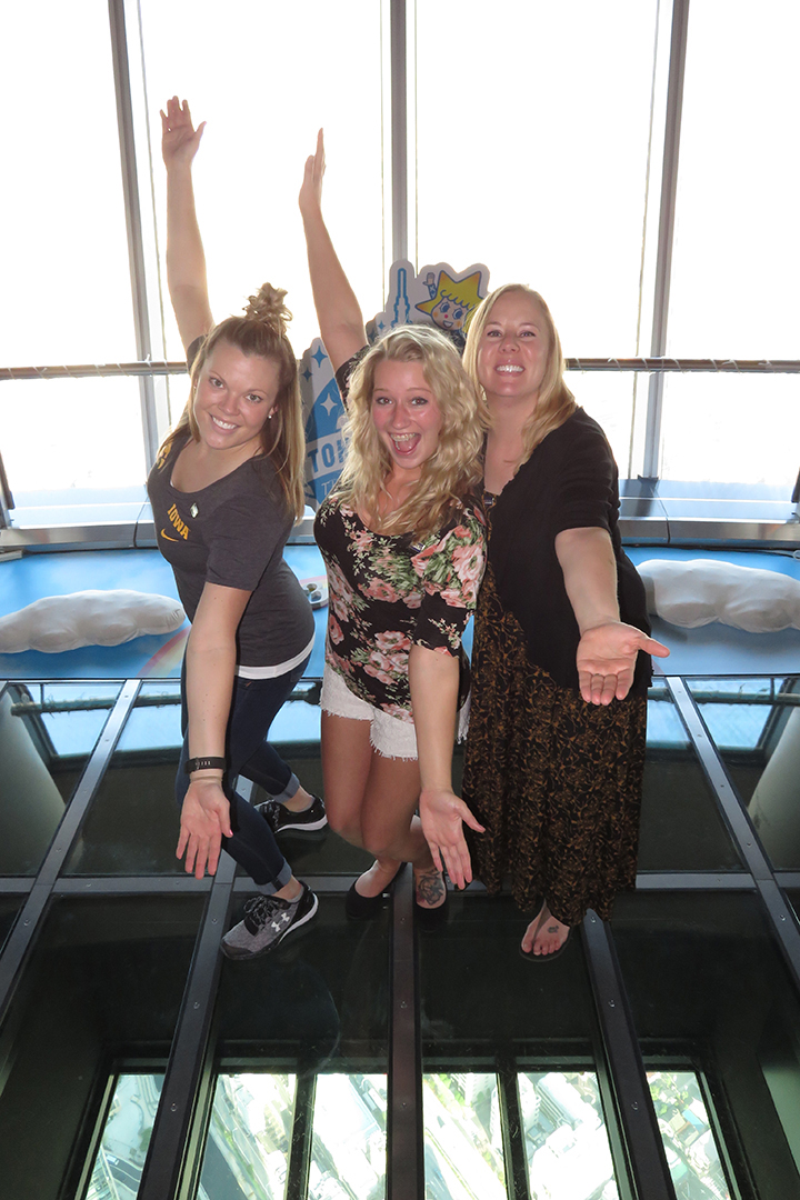 Three students standing on the glass floor